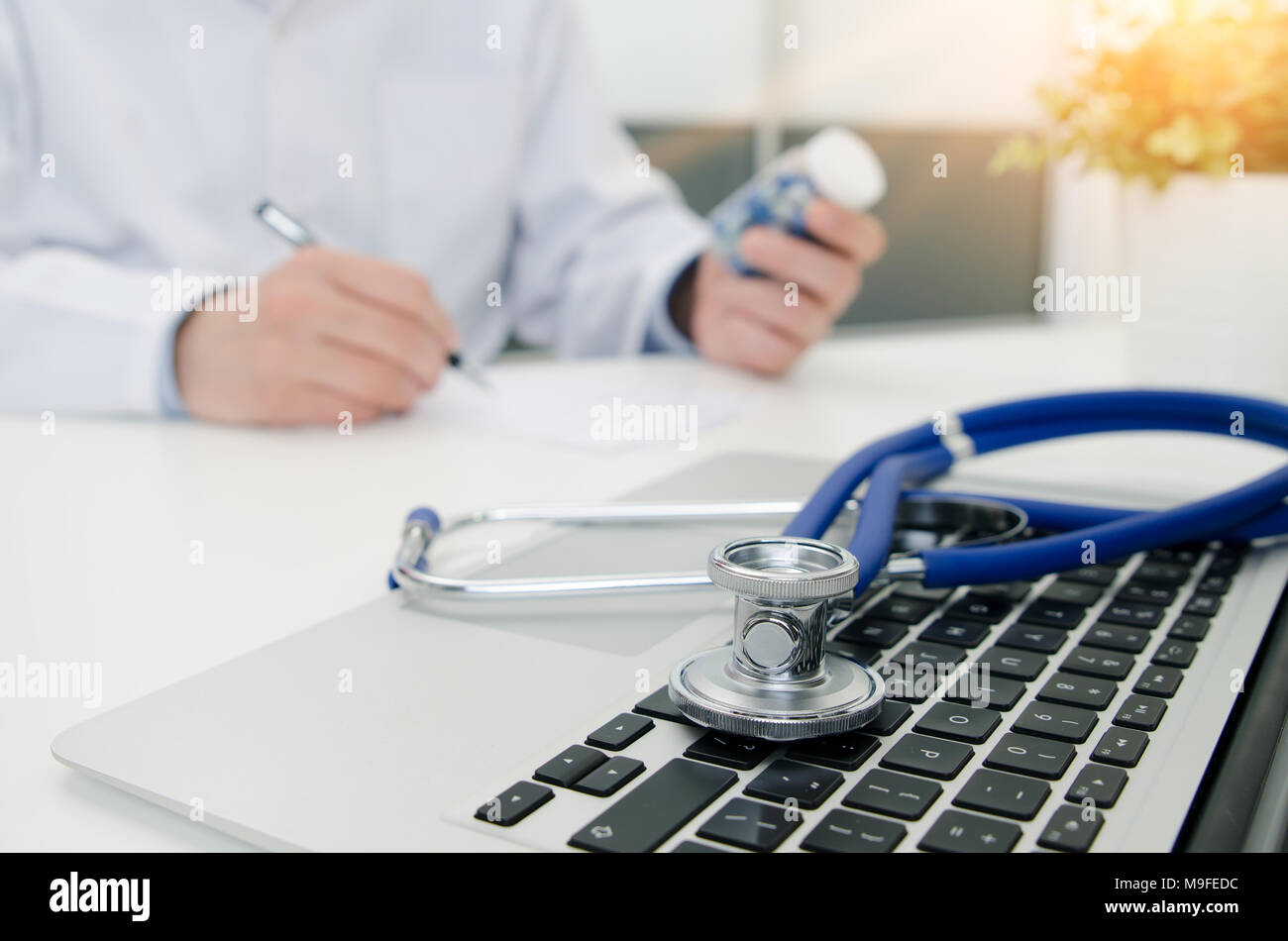 Doctor working in hospital. Stethoscope on laptop keyboard. Medical doctor healthcare consultation in polyclinic or hospital concept Stock Photo