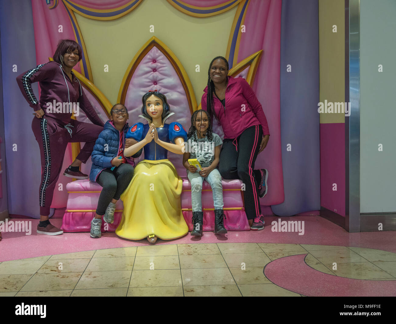 A Family traveling through the Orlando International Airport posing along side of Snow White. Stock Photo