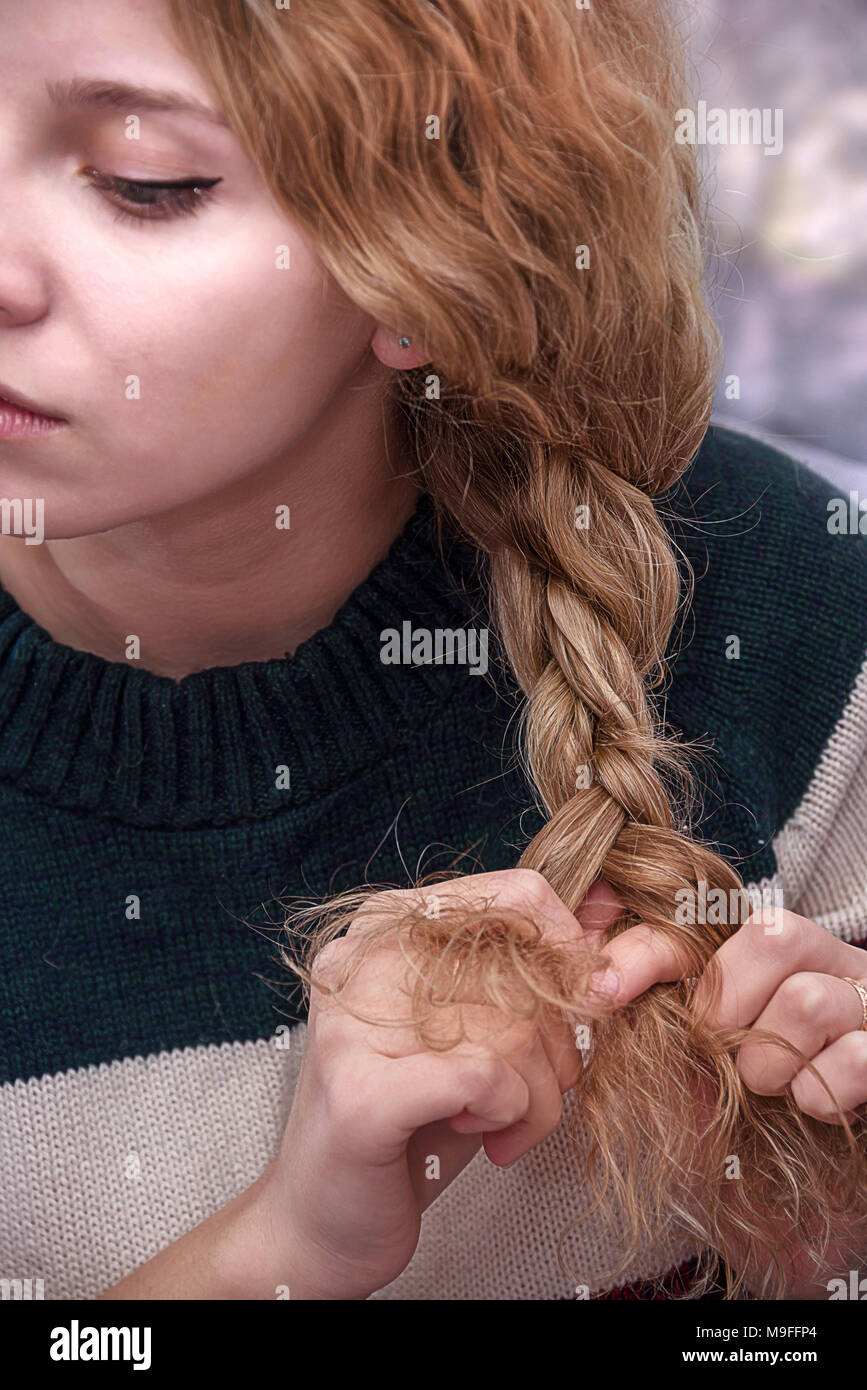 beautiful girl ties her hair in pigtails, beauty care concept, beauty concept Stock Photo