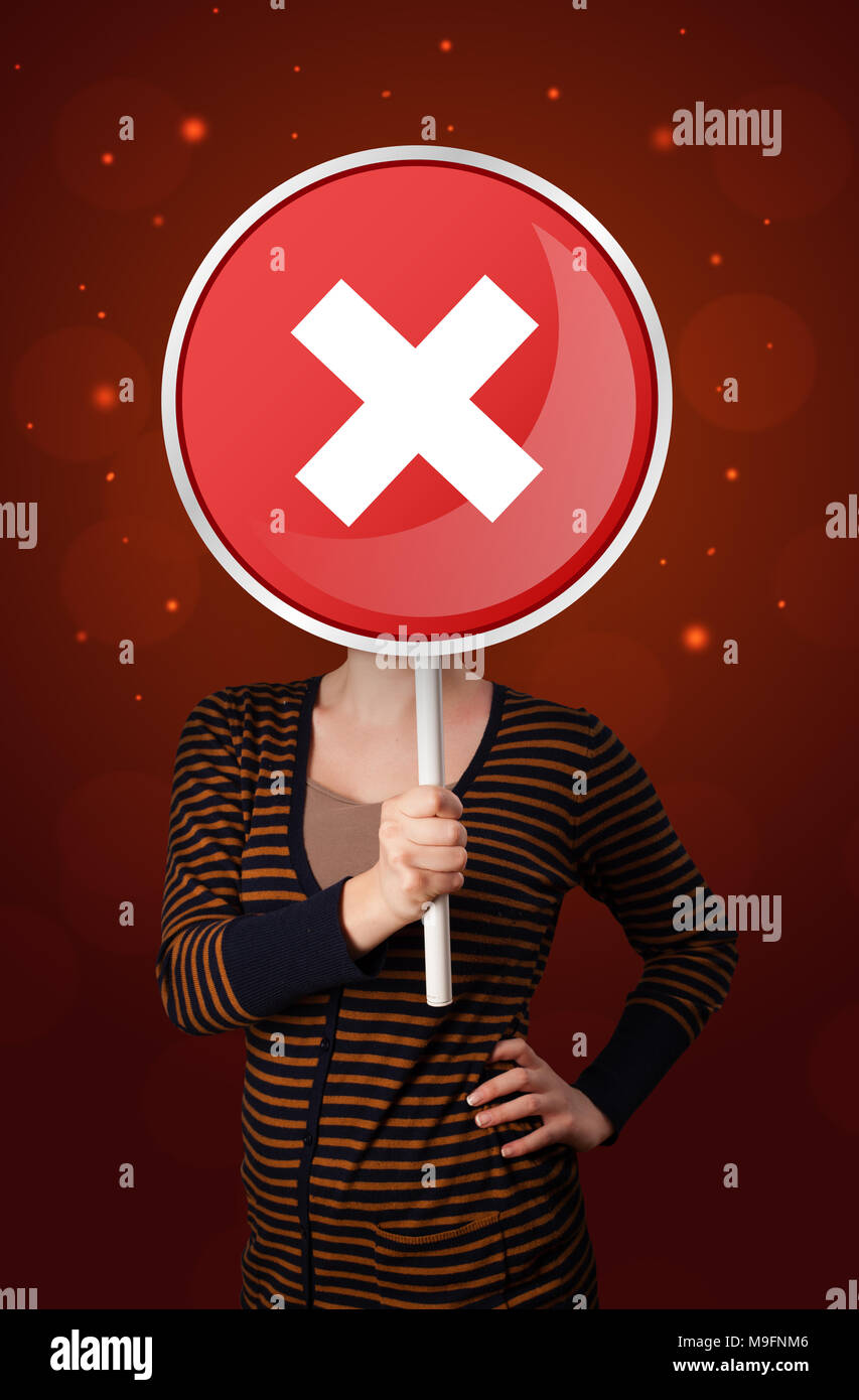 Casual young woman holding round red sign with white cross  Stock Photo