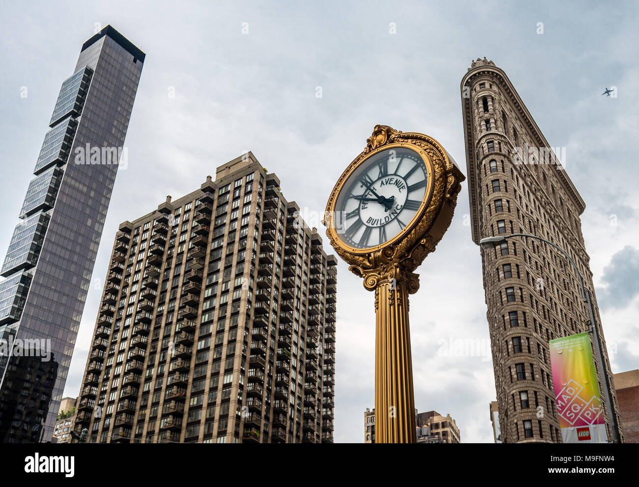 View of One Madison building, Flatiron Building and the cast-iron sidewalk clock (outside the Toys Center), in Madison Square, in Manhattan, NYC. Stock Photo