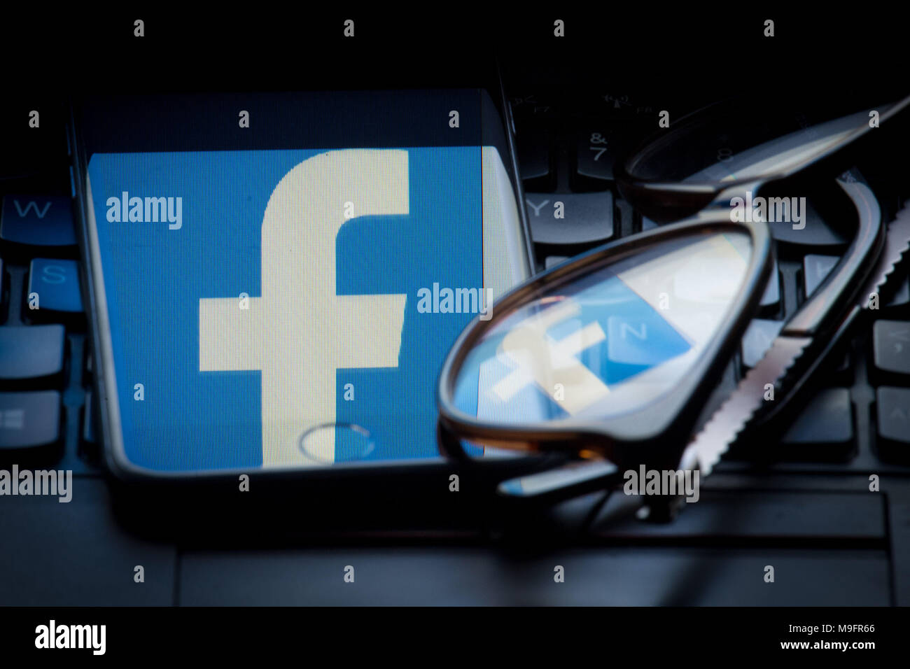 The logo of social networking site Facebook is reflected on the screen of a smartphone and a pair of glasses resting on a laptop keyboard. Mark Zuckerberg has yet to respond to a request by MPs to appear before them to give evidence about Facebook's links to political analysis consultancy Cambridge Analytica, the Department for Culture, Media and Sport (DCMS) said. Stock Photo