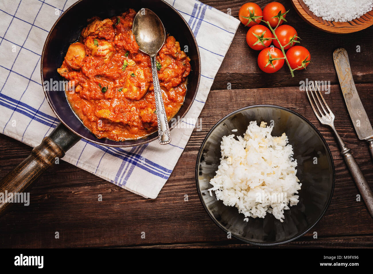 Traditional indian cuisine. Spicy tikka masala with rice on wood table top view Stock Photo