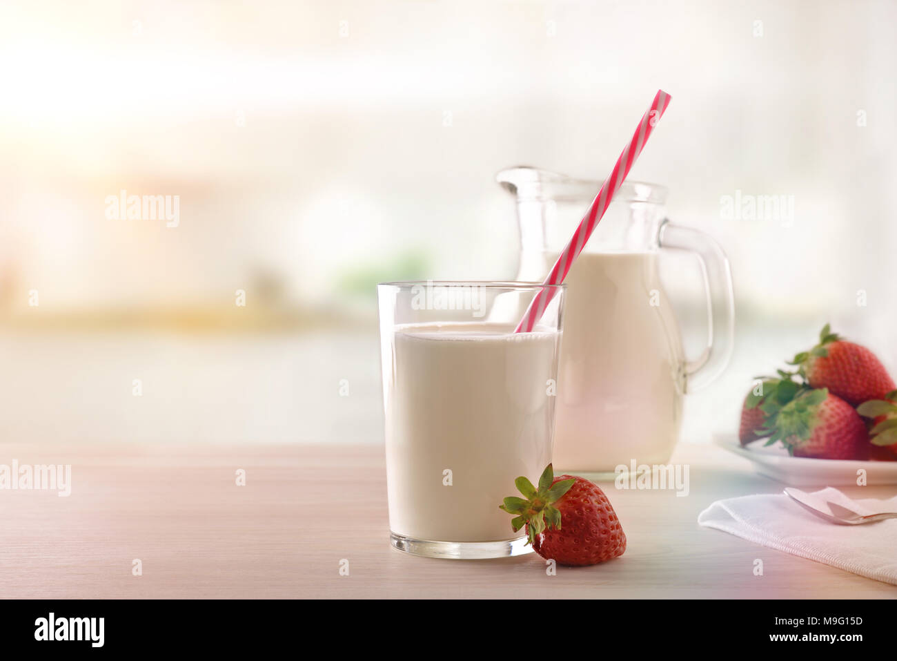 Breakfast milk and strawberries on a white wooden kitchen table. Horizontal composition. Front view Stock Photo
