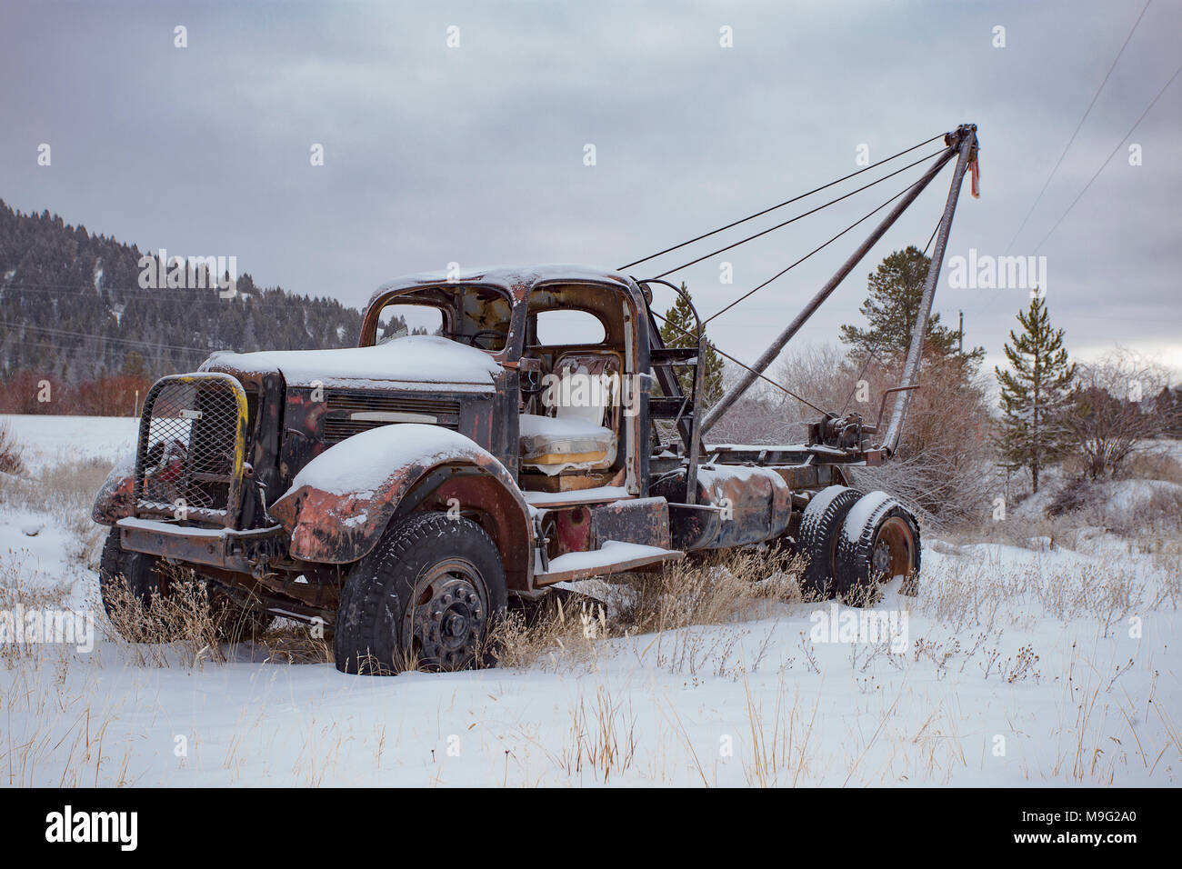 A 1947 White Super Power 2 1/2 ton pole truck in a snow-covered landscape near Silver Lake, Montana. Stock Photo