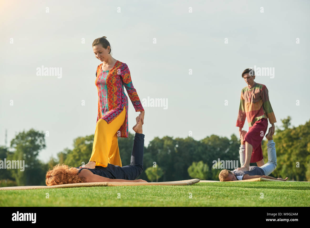 Group thai massage, step on back pose. Getting massage and relaxing outdoor Stock Photo Alamy