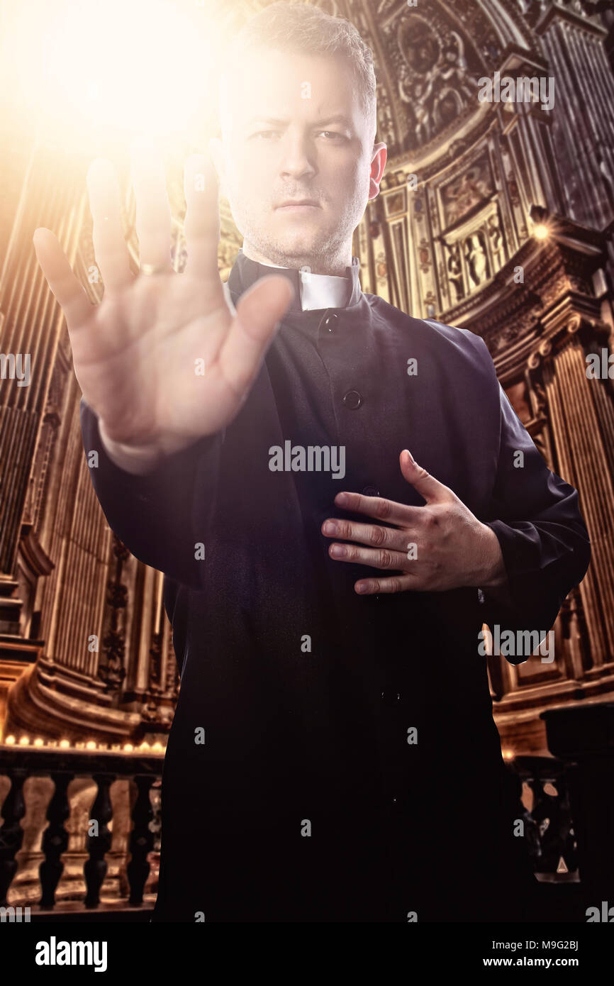 priest with an outstretched hand at the church Stock Photo
