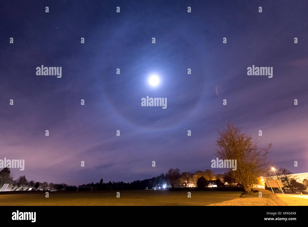 Rocester, Staffordshire, UK. 25 March 2018. UK Weather: the Moon is seen with a 22º halo formed by ice crystals, which refract the light off the moon, creating a ring around it. Seen and taken from Rocester, Staffordshire, on the night of the 25 March 2018. Credit: Richard Holmes/Alamy Live News Stock Photo