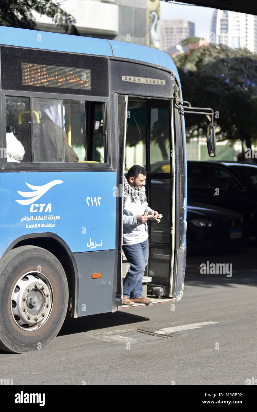 A bus in Cairo with an assistant of the bus driver standing in the door ...