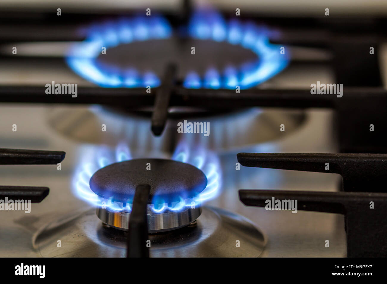Natural gas burning on kitchen gas stove in the dark. Panel from