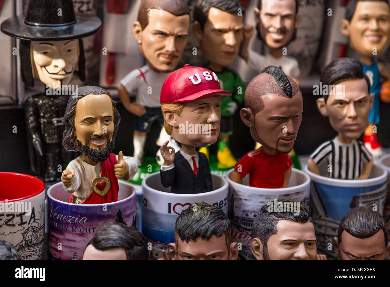 Close-up of a display of souvenir caricature coffee mugs, centered on a caricature mug of Donald Trump in a red baseball cap and making a hand gesture Stock Photo