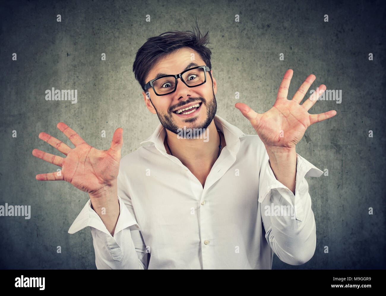 Young excited man making faces and gesturing in surprise looking at camera. Stock Photo