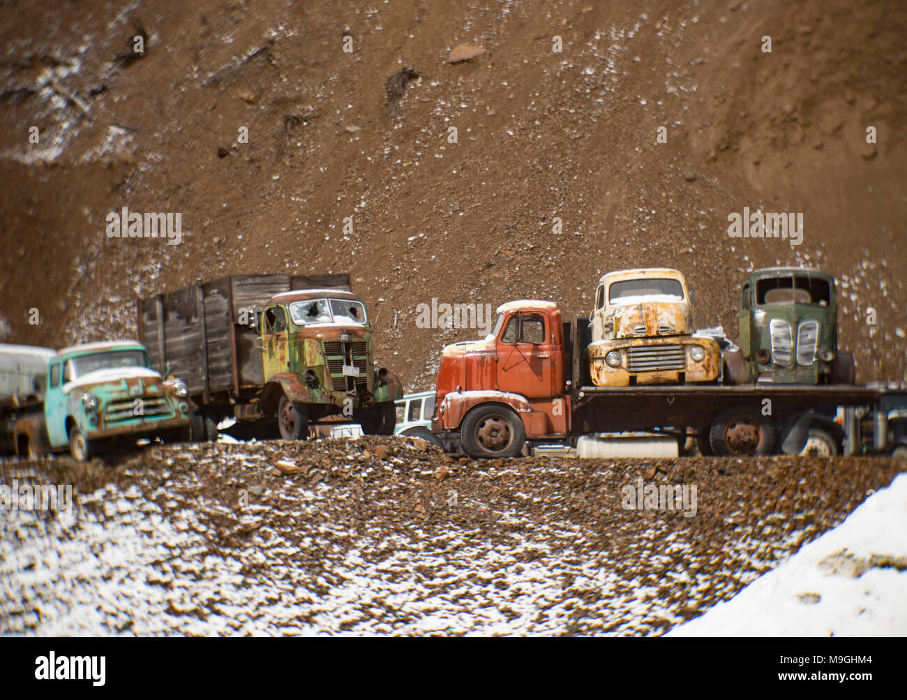 A line of old rusty work trucks from the 1940s and 1950s, in an old quarry, east of Clark Fork Idaho. This image was shot with an antique Petzval lens Stock Photo