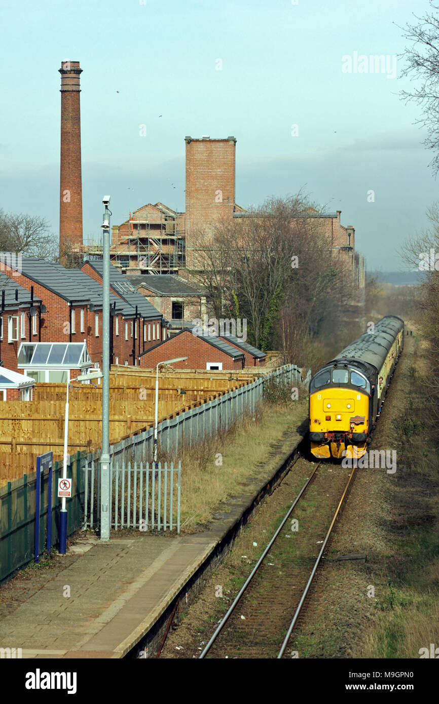A railway enthusiast’s train passes Burscough Junction station and the former corn mill in West Lancashire. The train was called the Lancs Links tour. Stock Photo