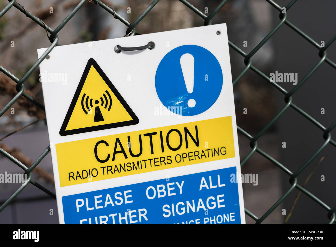 Warning sign at the bottom of a cellular / mobile phone transmitter mast. Stock Photo
