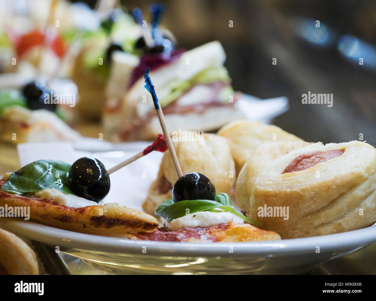 Large selection of pastries and cakes on display in refrigerated glass