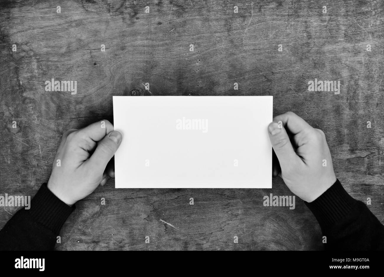 monochrome photo male hands holding a white blank sheet of paper Stock ...