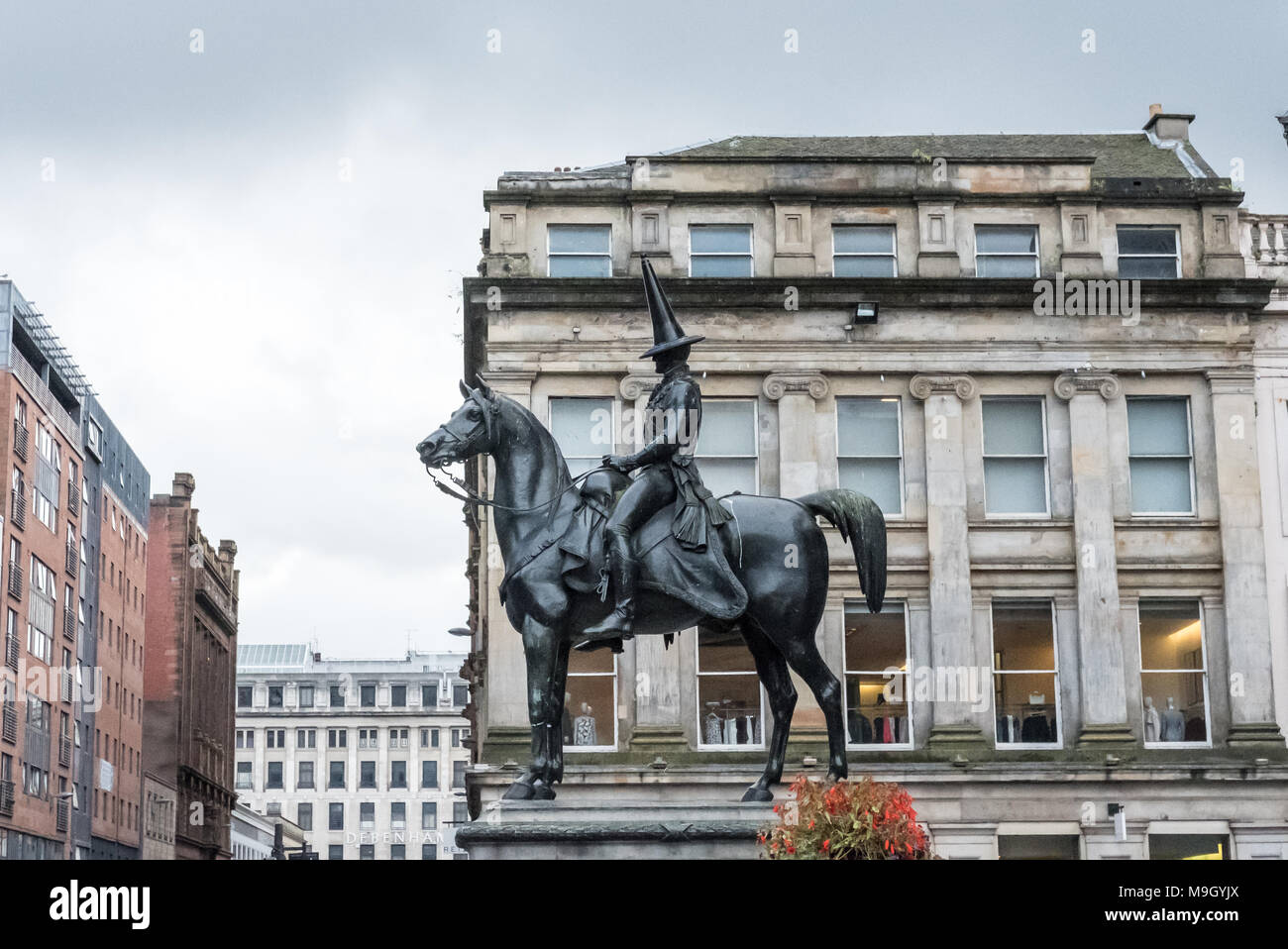 Statue of Duke of Wellington, riding a horse, wearing a black traffic cone on his head. In front of Gallery of Modern Art, Royal Exchange Square, Glas Stock Photo