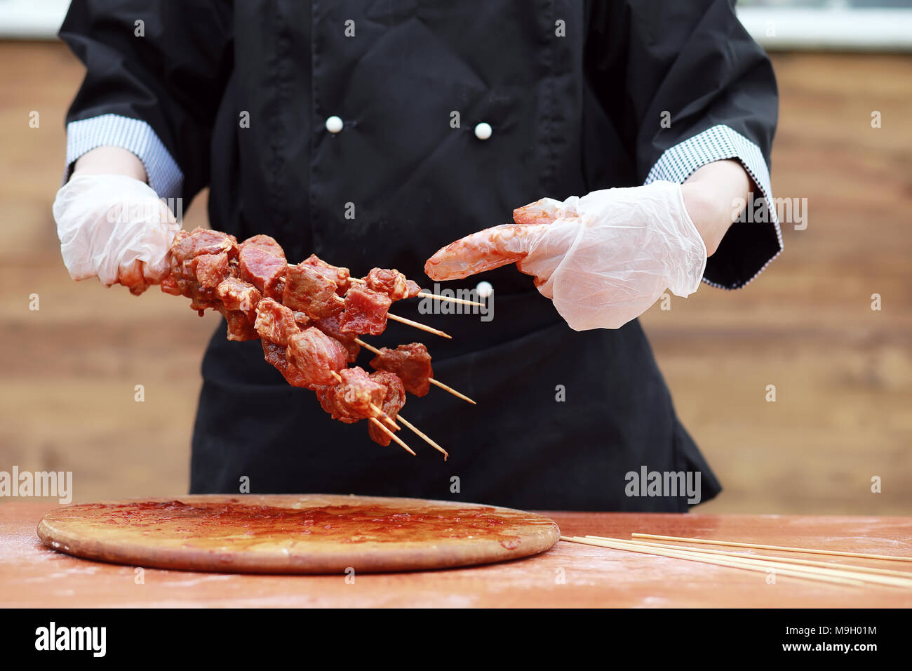 How Cookspling Meat The cook cuts meat for cooking barbecue Stock Photo - Alamy