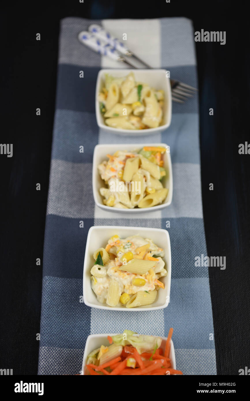 line of pasta salad dishes in portrait shape Stock Photo