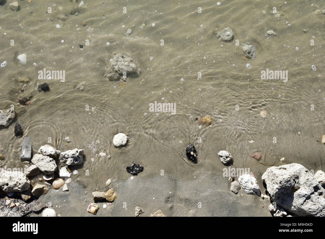 Sand and sea waves on a sandy beach in Dammam Stock Photo