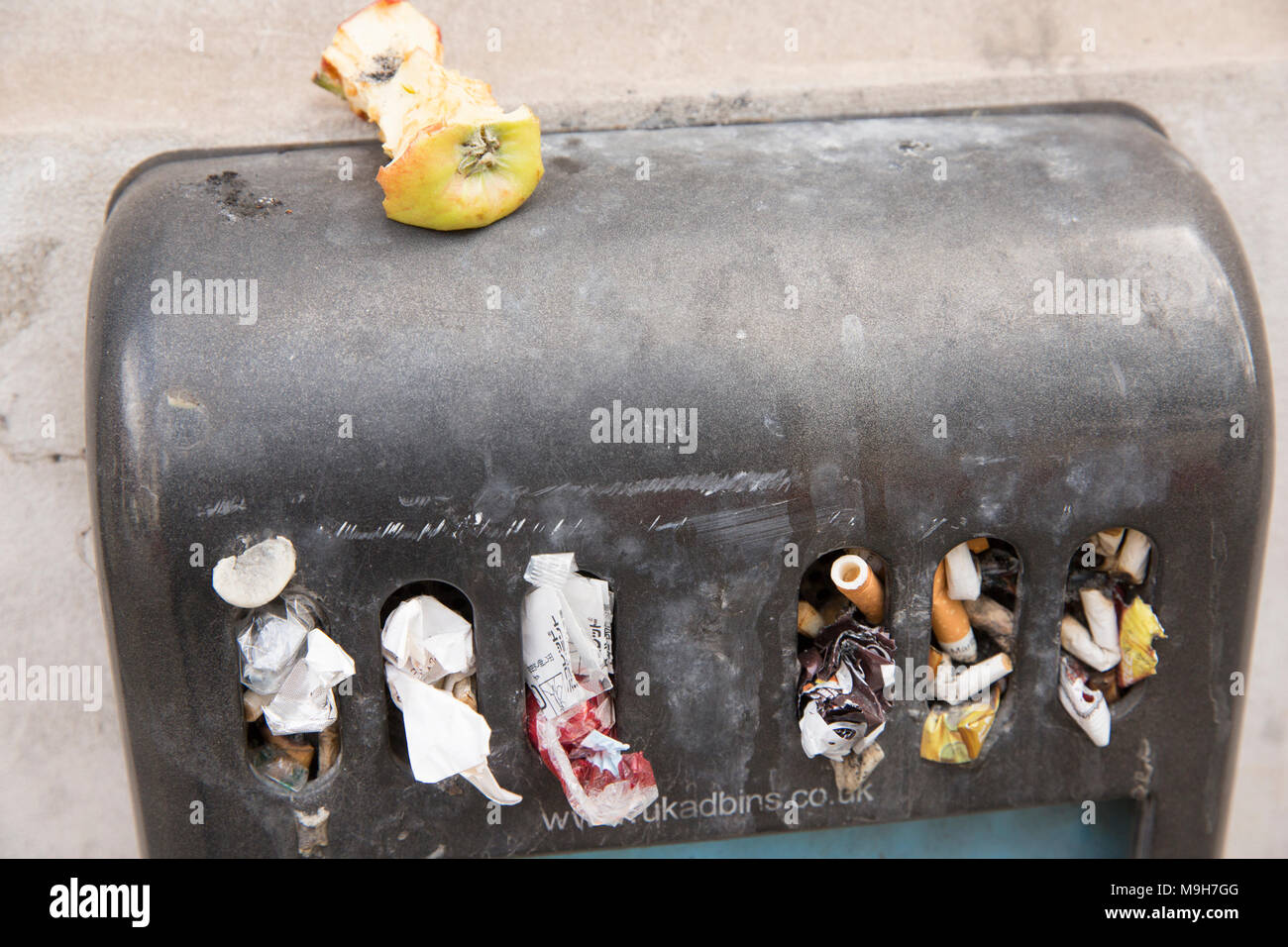An outdoor ashtray that has been used for litter as well as cigarette ends. London England UK GB Stock Photo