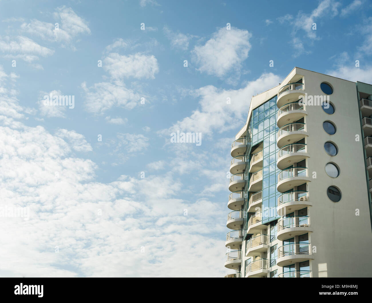 Modern building against vibrant blue sky with clouds Stock Photo - Alamy