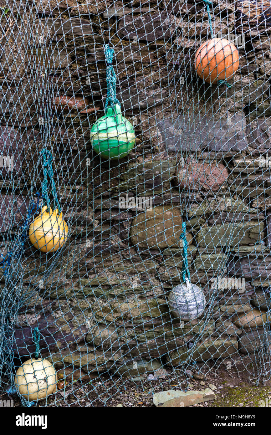 Decorative fishing net and buoys on a wall in Portmagee, County Kerry Ireland Stock Photo
