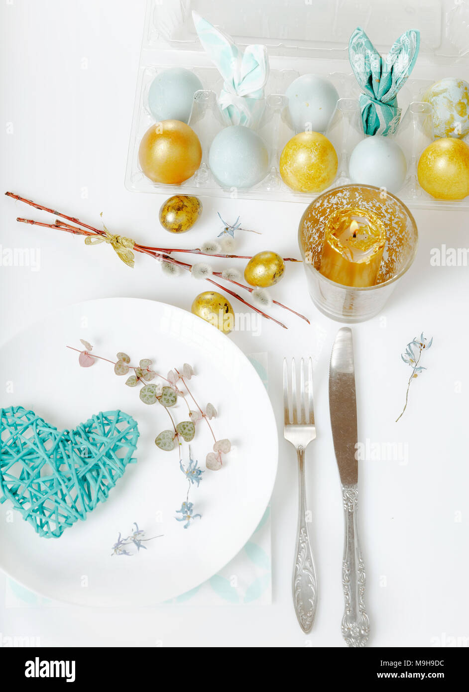 Easter table setting with gold and blue eggs and cutlery. Holidays background Stock Photo