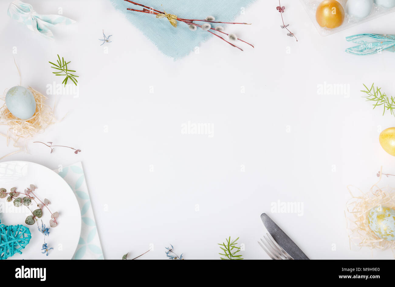 Easter table setting with gold and blue eggs and cutlery on white. Holidays background. Backdrop with copy space, flat lay, top view. Stock Photo