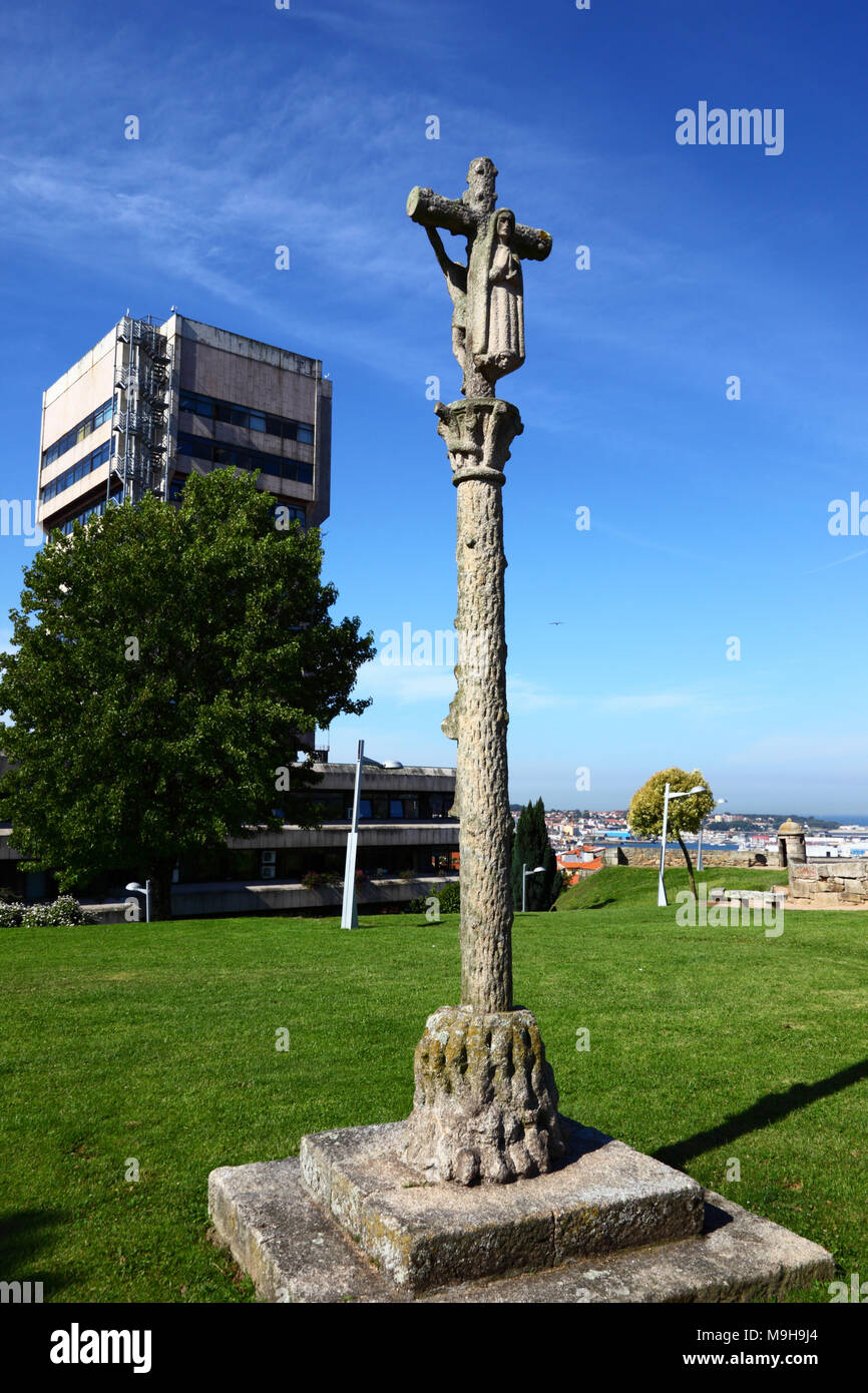 Traditional stone calvary cross or cruceiro in Castillo de San Sebastian, City Council / Concello building in background, Vigo, Galicia, Spain Stock Photo
