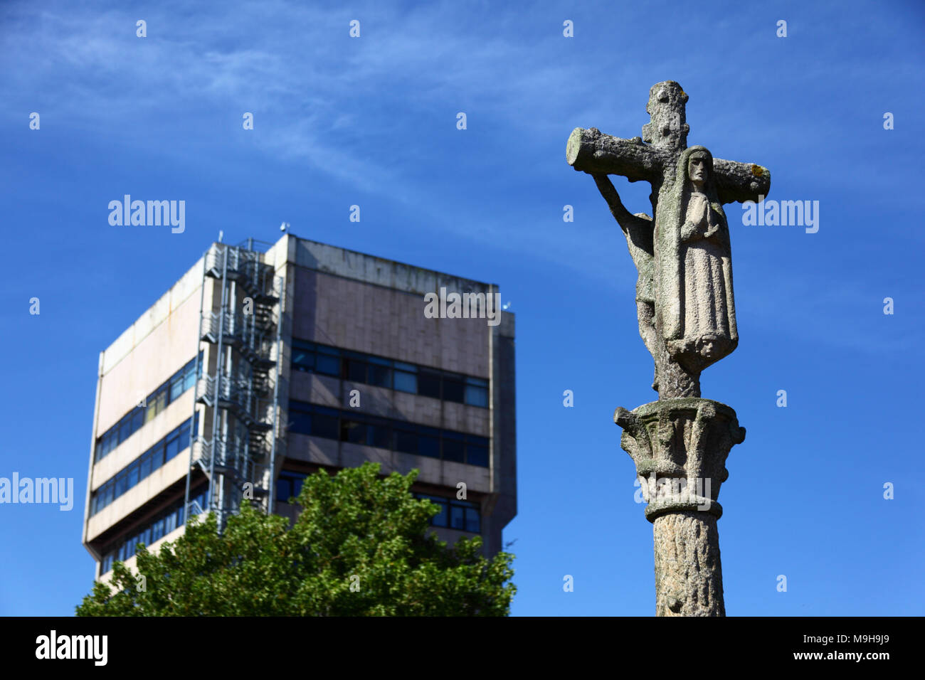 Traditional regional stone calvary cross called a crucero / cruceiro, City Council / Concello building in background, Vigo, Galicia, Spa Stock Photo