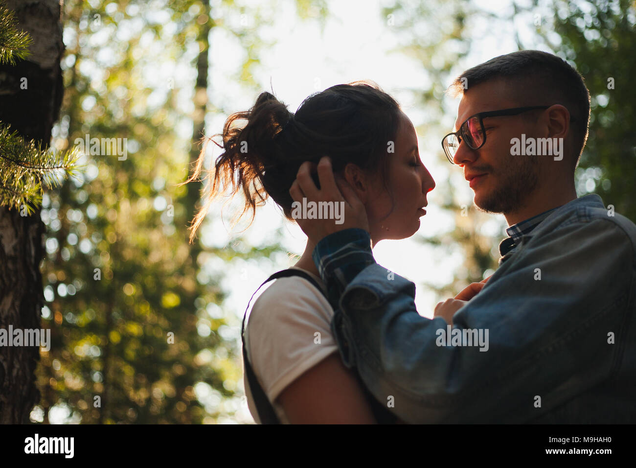 A beautiful young couple kiss in the forest Stock Photo