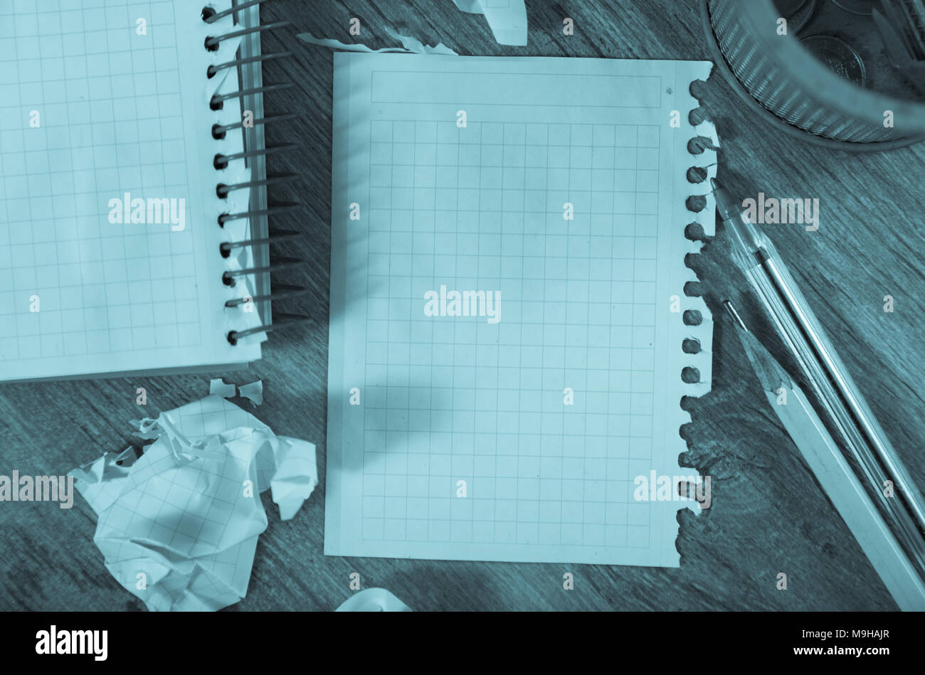 Crumpled empty pages and notebook lying on wooden surface Stock Photo
