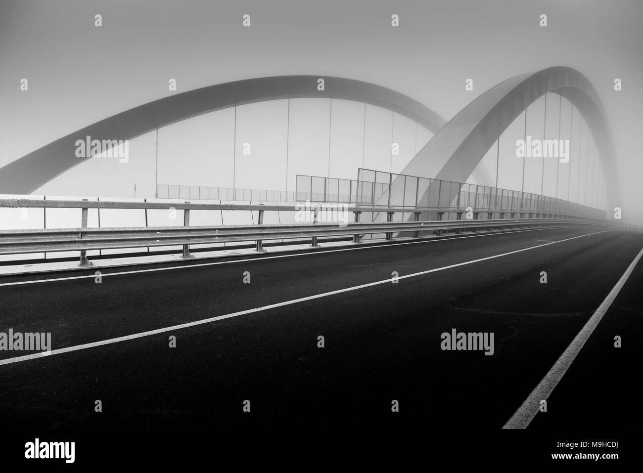 Road bridge in the fog - black and white image Stock Photo - Alamy