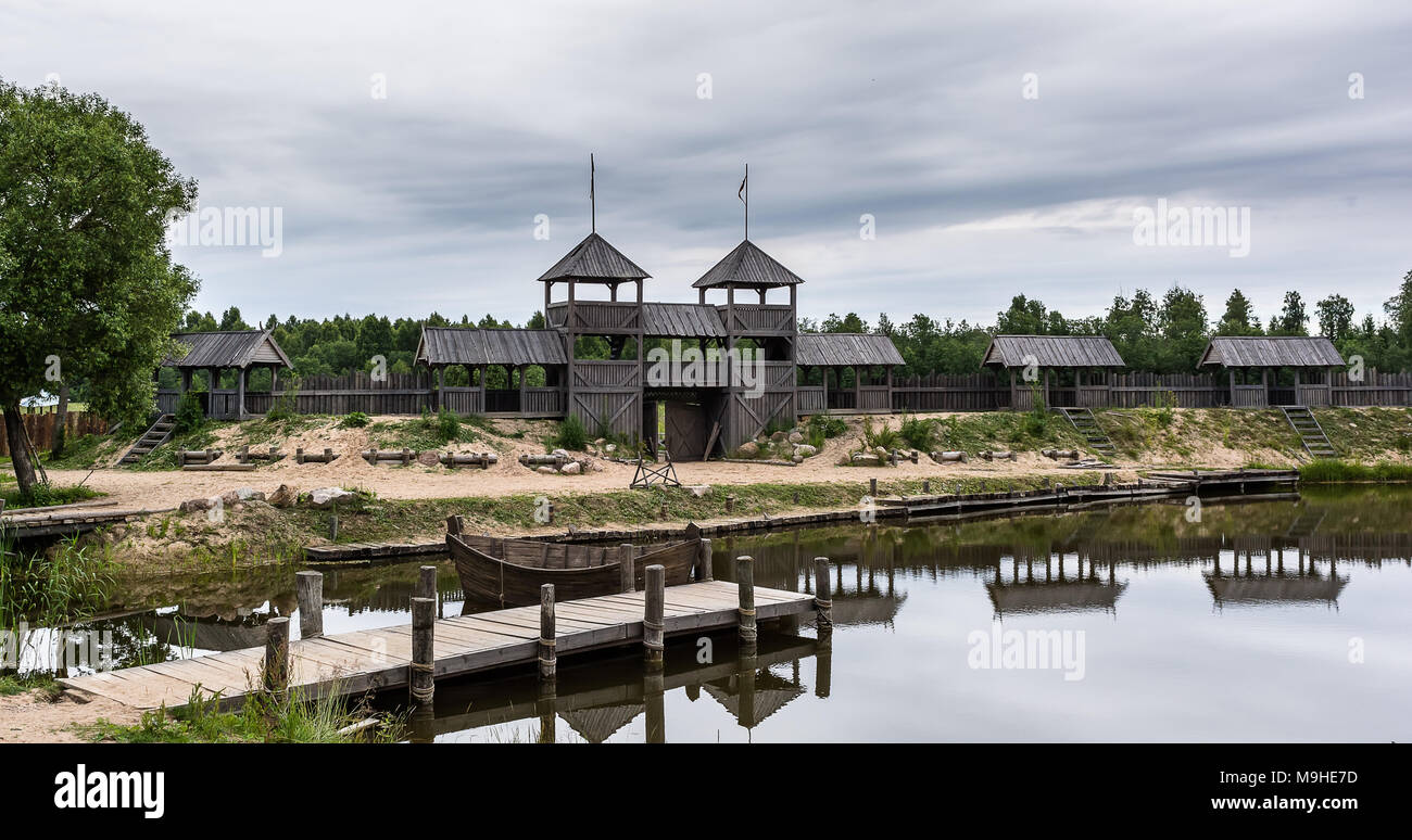 Picturesque medieval scenery near the lake with old wooden defensive wall and pier. The picture was shoot in the Cinevilla filmtown in Latvia. Stock Photo