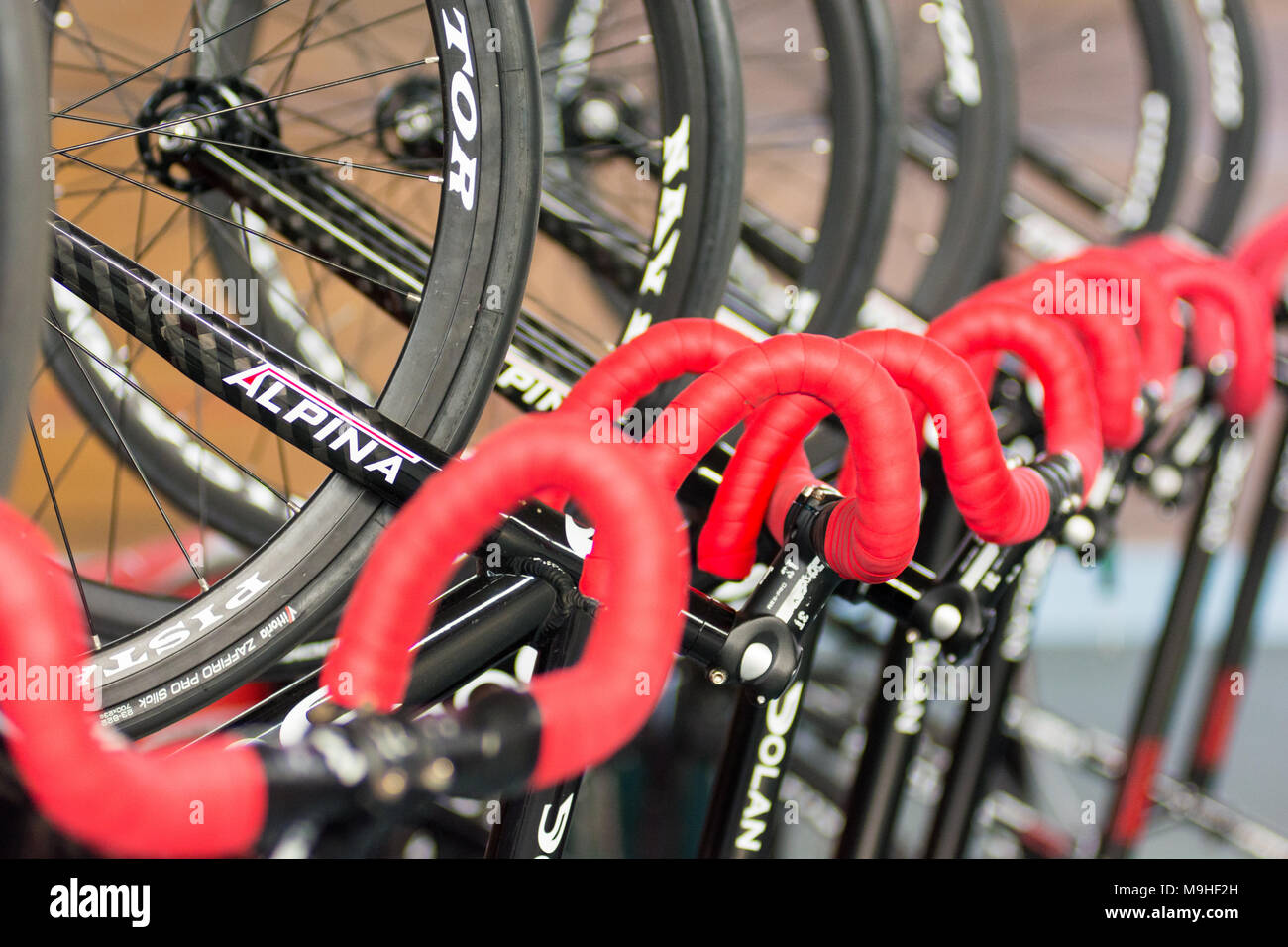Alpina velodrome racing bicycles with red taped handle bars stacked upright in a row. Stock Photo