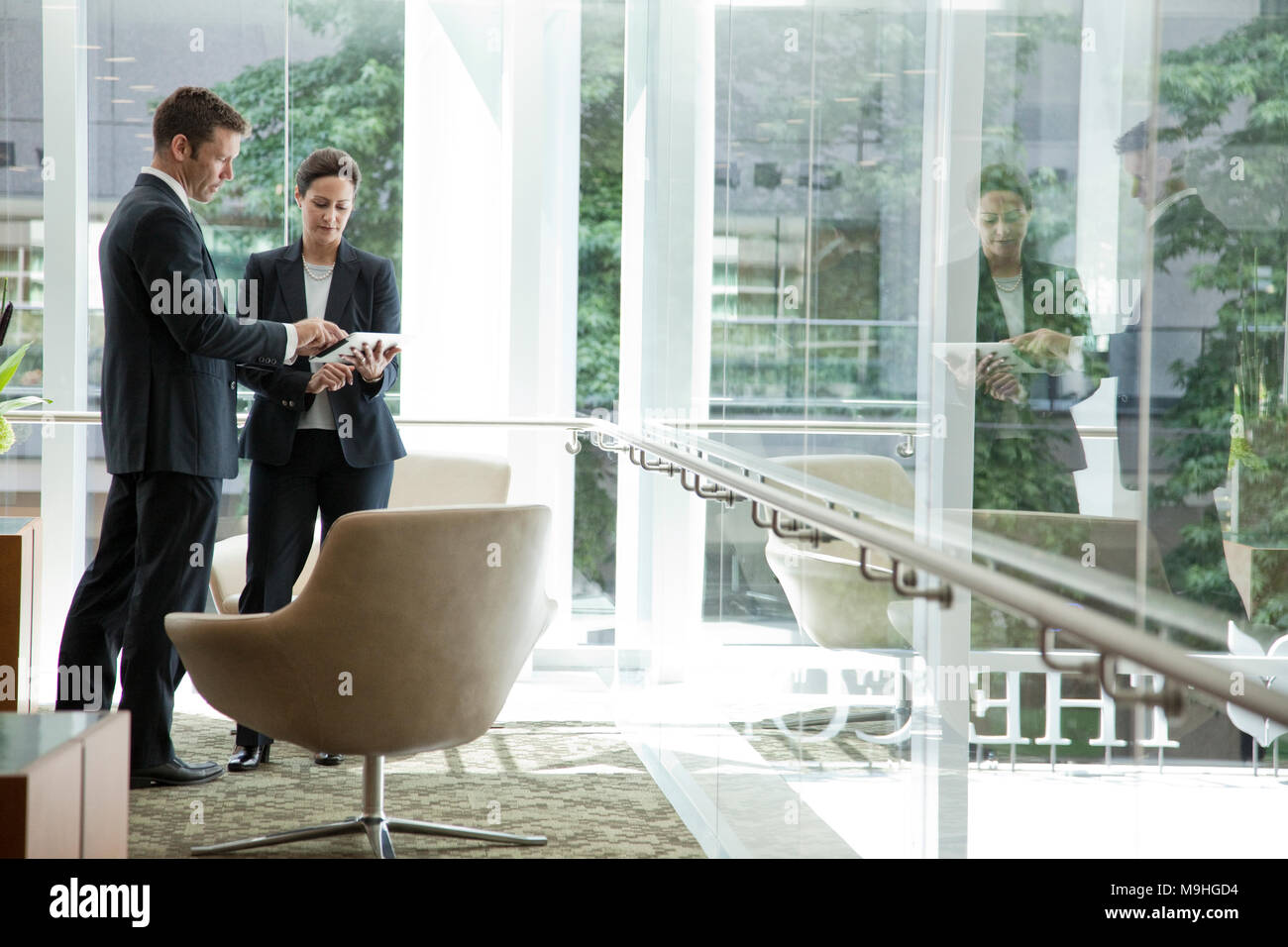 Caucasian businessman and woman meeting in a lobby area of a large ...