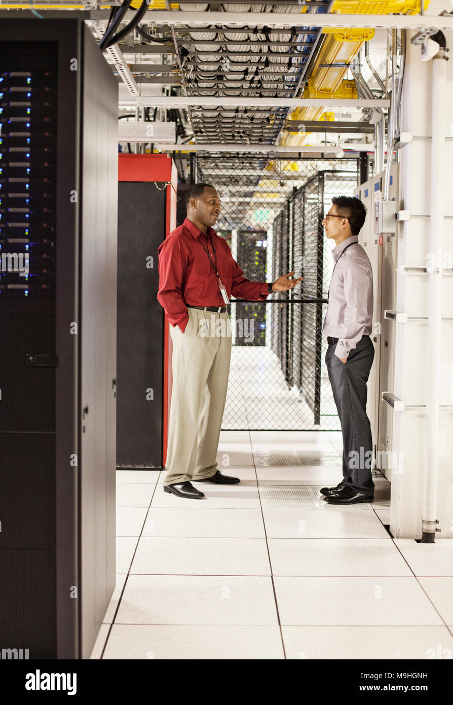Computer technicians discussion an issue in a large computer server farm. Stock Photo