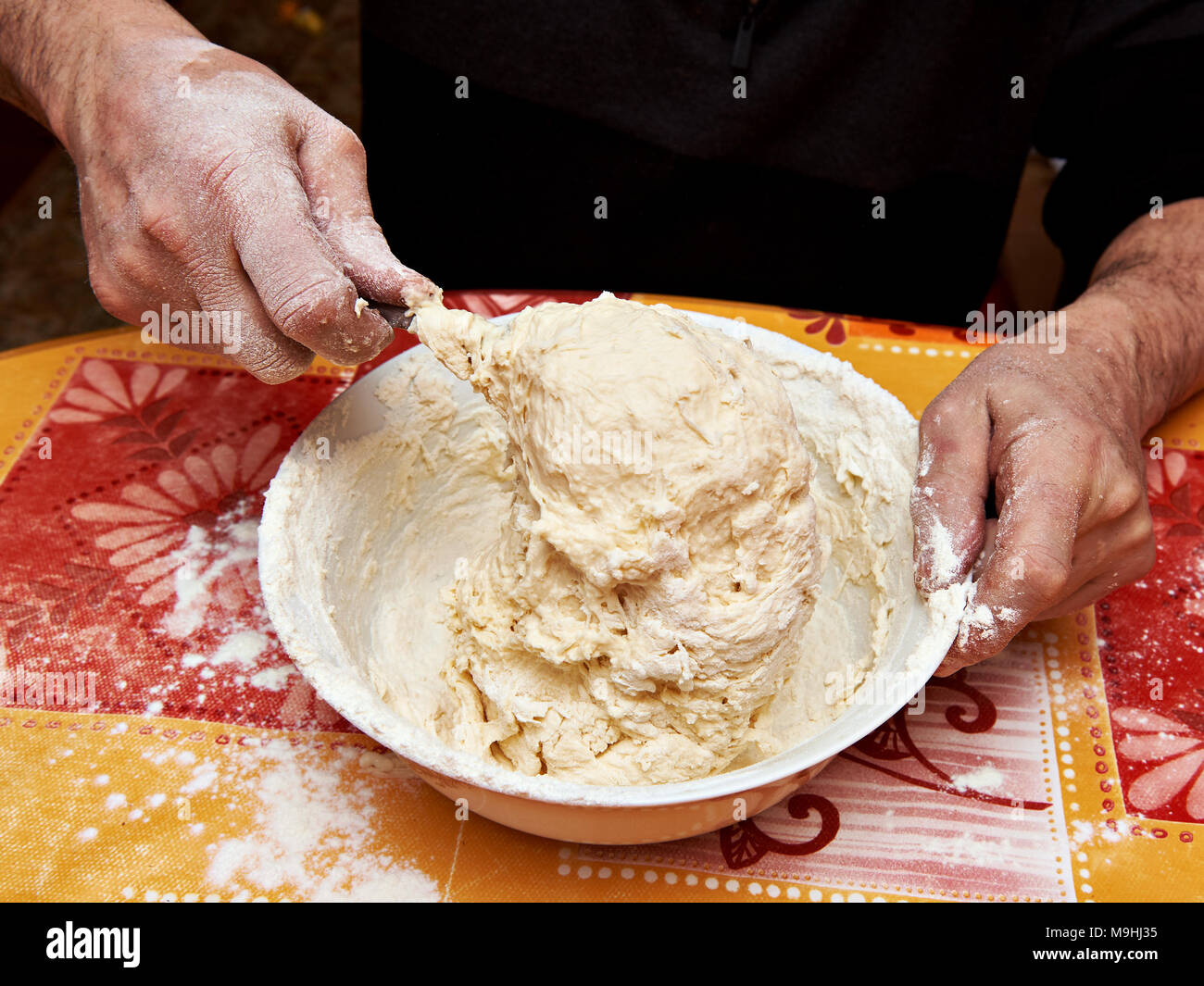 Mens hands knead the dough in bowl Stock Photo Alamy