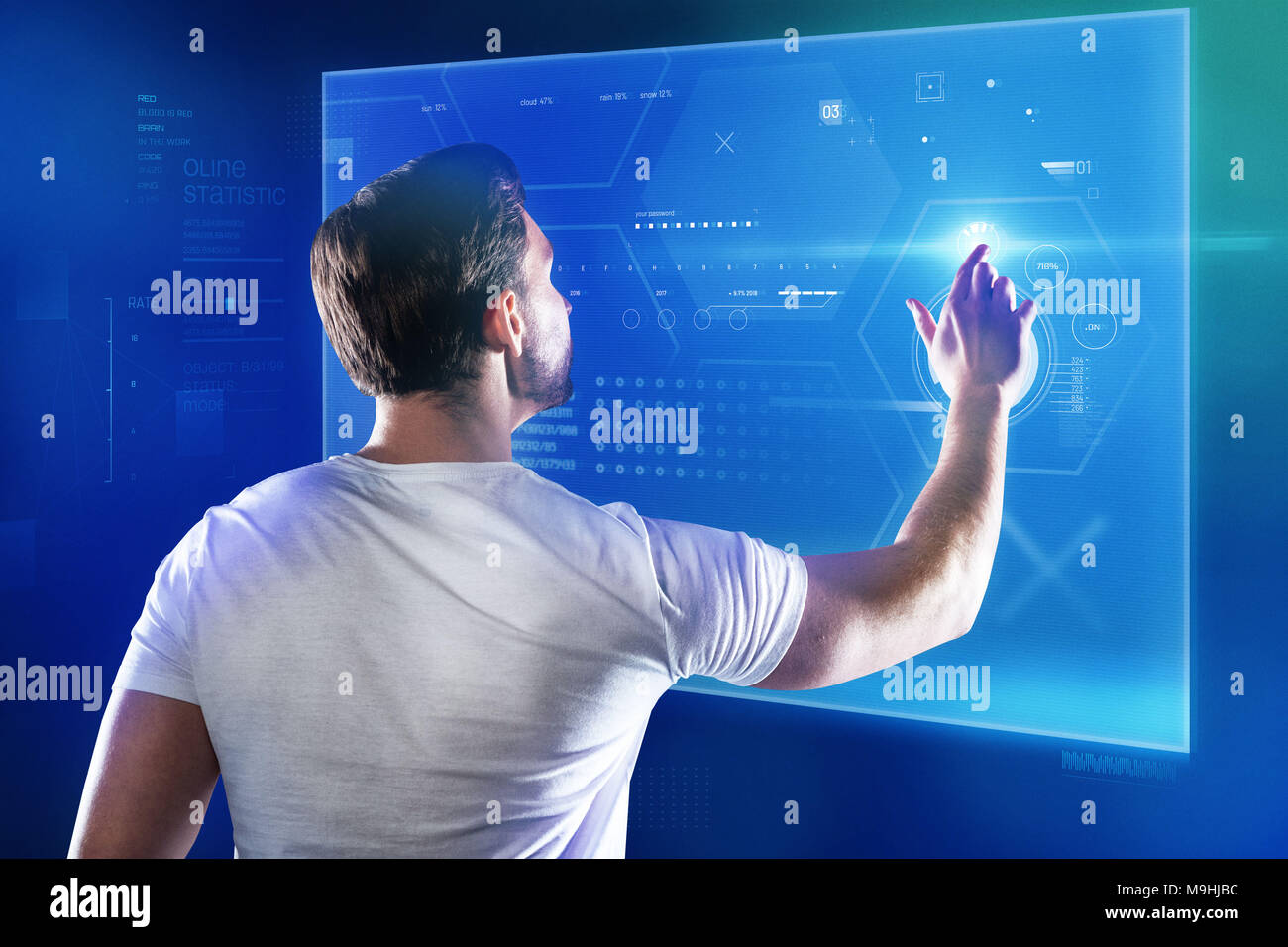 Skilled programmer working with a new device and touching a transparent screen Stock Photo
