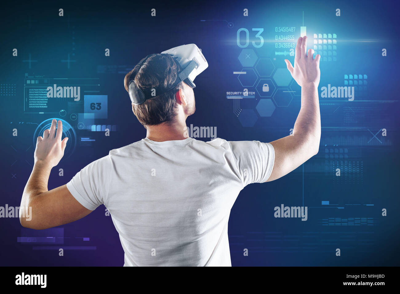 Attentive programmer wearing virtual reality glasses and working at his ...