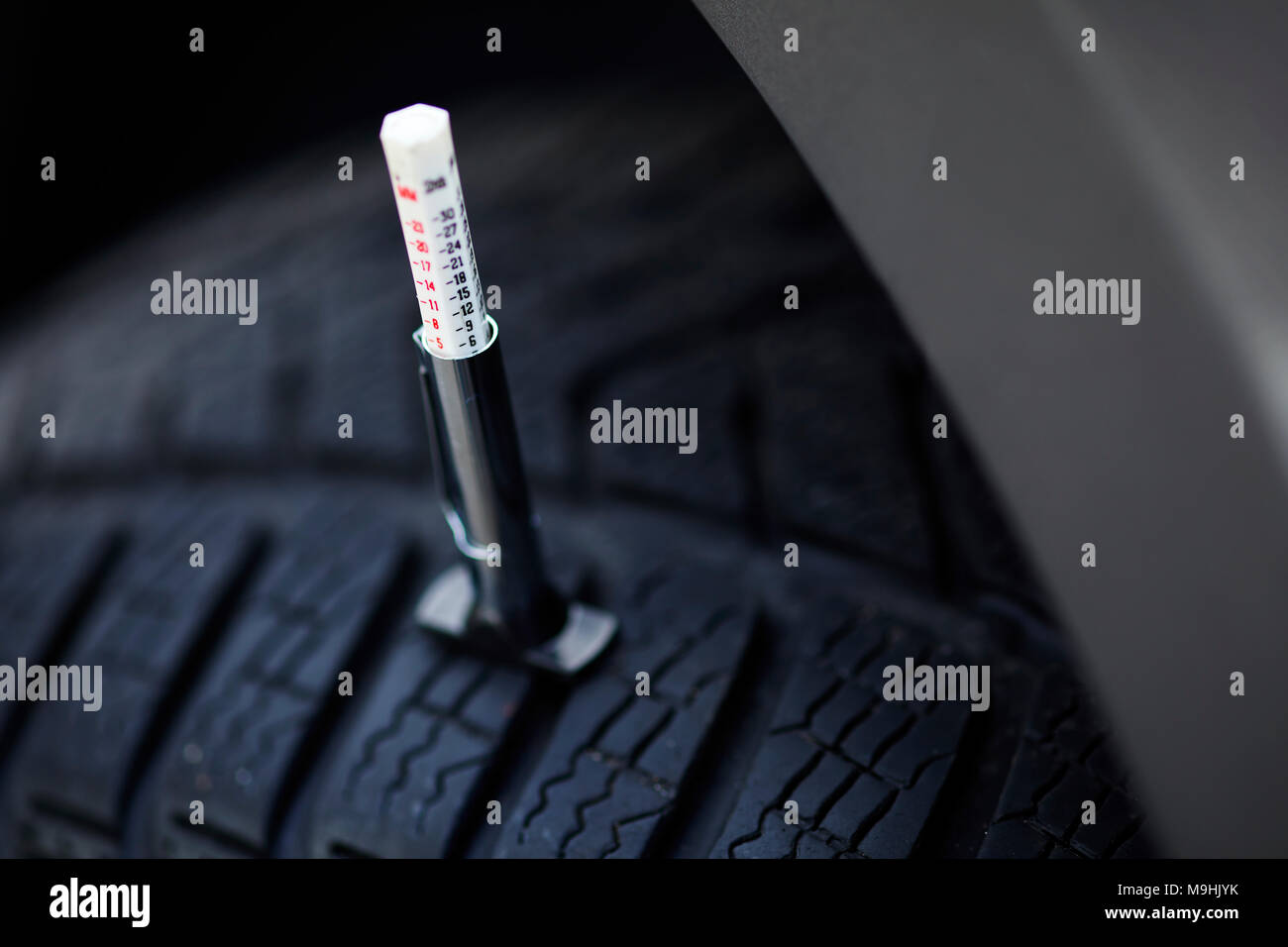 Taking tyre tread depth gauge readings Stock Photo