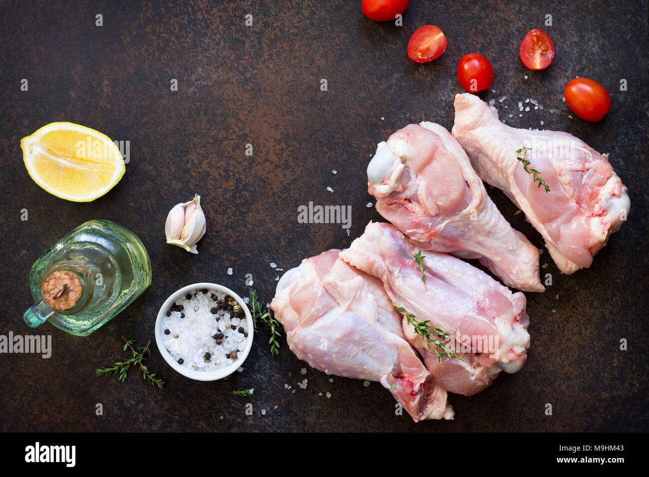 Fresh meat. Raw turkey shin and spices on a stone table. Copy space. Stock Photo