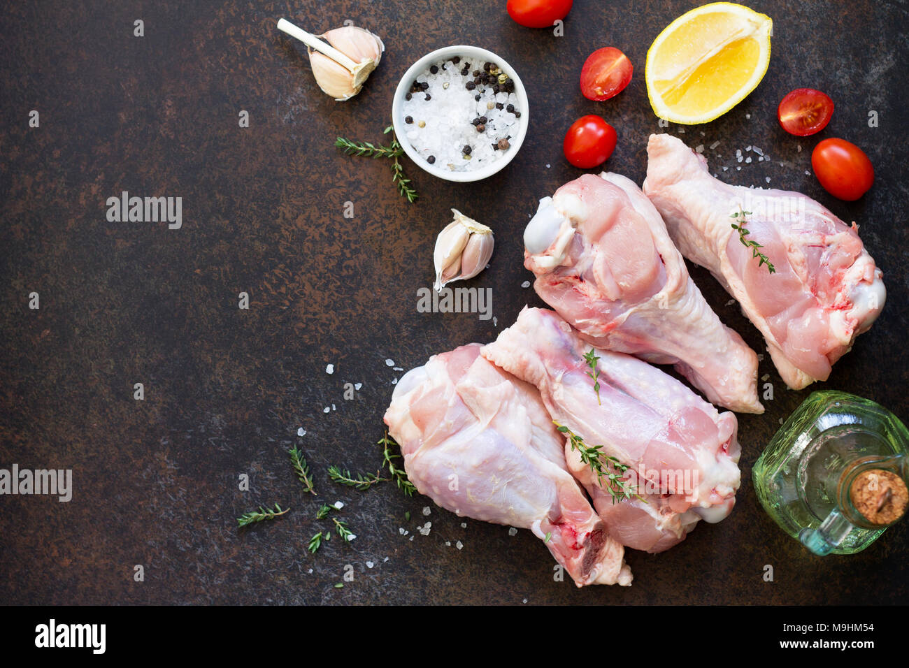Fresh meat. Raw turkey shin and spices on a stone table. Copy space. Stock Photo