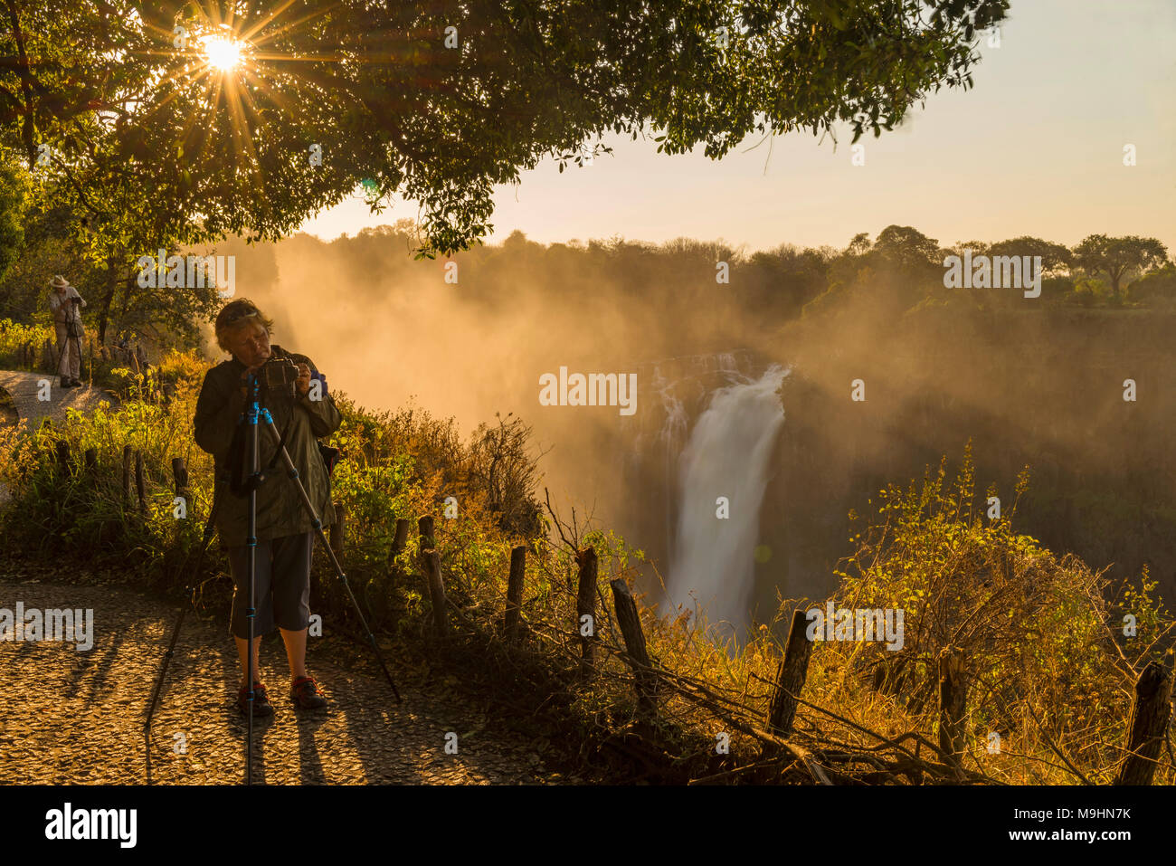 A tourist takes a picture of the Victoria Falls, Zimbabwe. Stock Photo