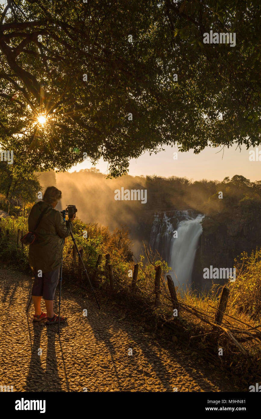 A tourist takes a picture of the Victoria Falls, Zimbabwe. Stock Photo