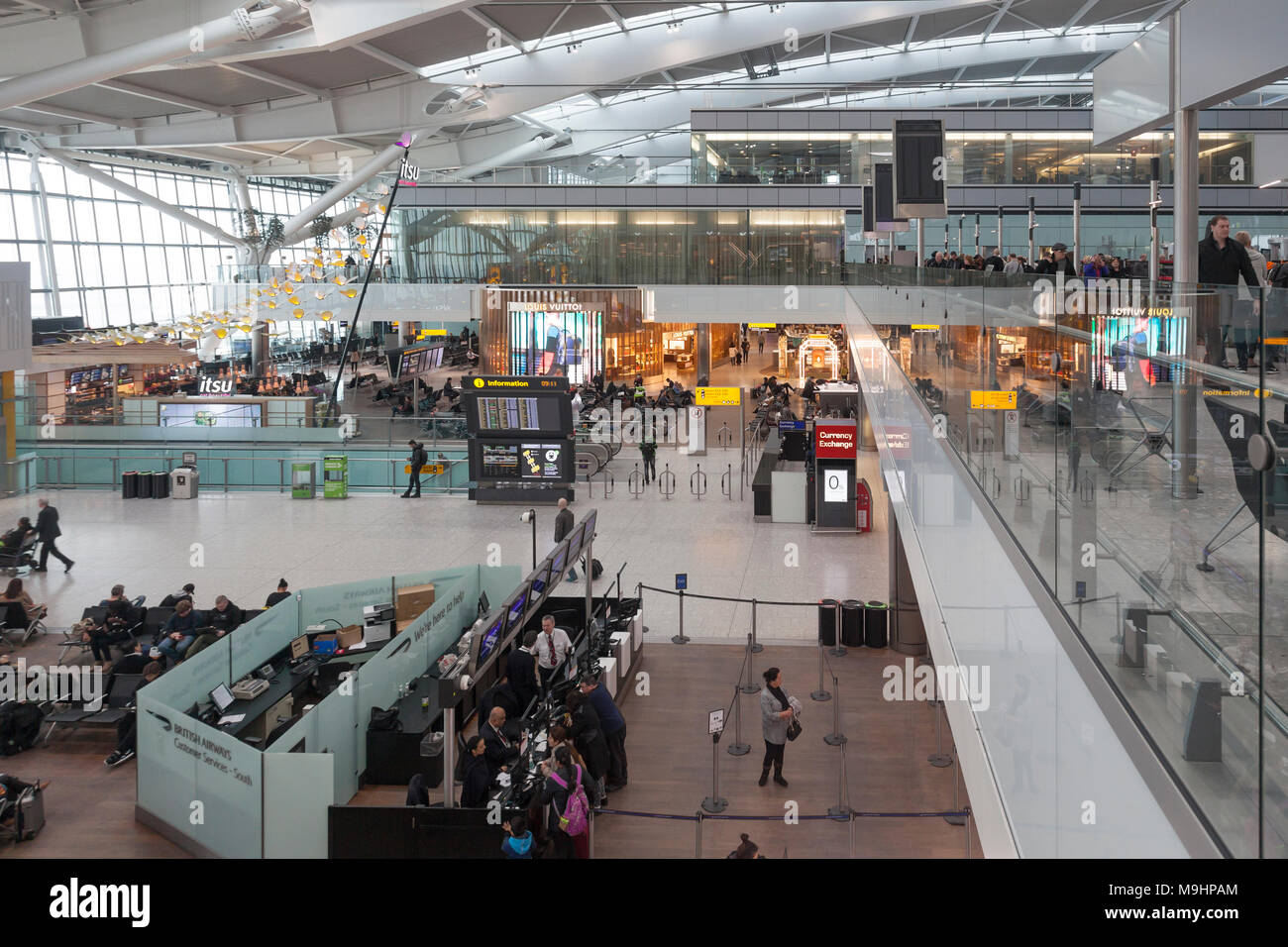 Part of the Terminal Five Departures Concourse at Heathrow Airport, London, with passengers, Customer service desk and staff, itsu fast food outlet, Stock Photo