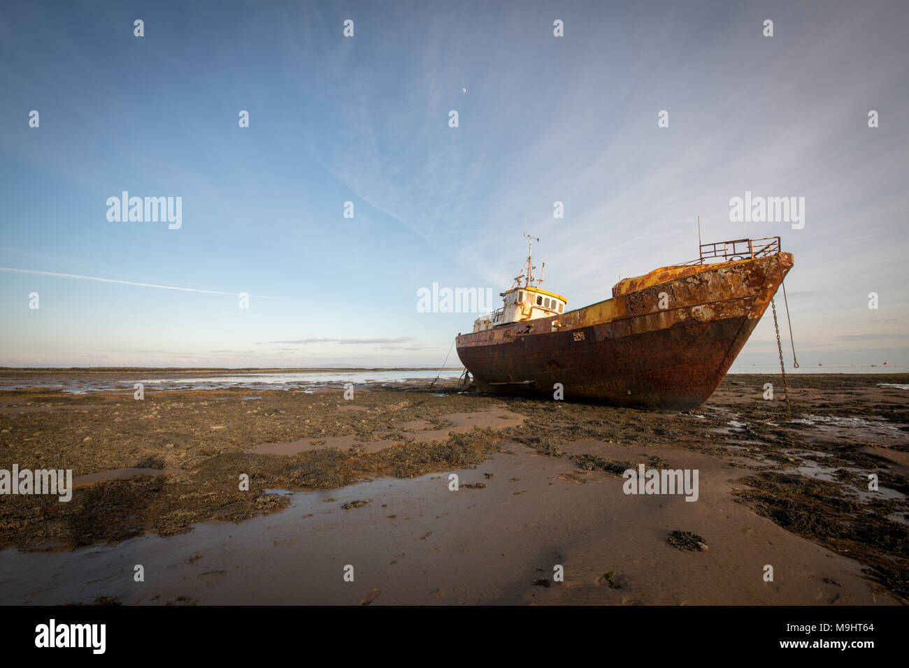 An old beached trawler slowly rusting on the beach at Rampside near Barrow-in-Furness, Cumbria. Stock Photo