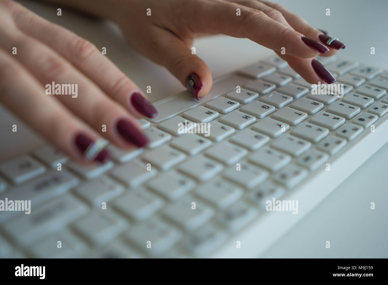 A woman is typing a message on a computer keyboard close-up Stock Photo